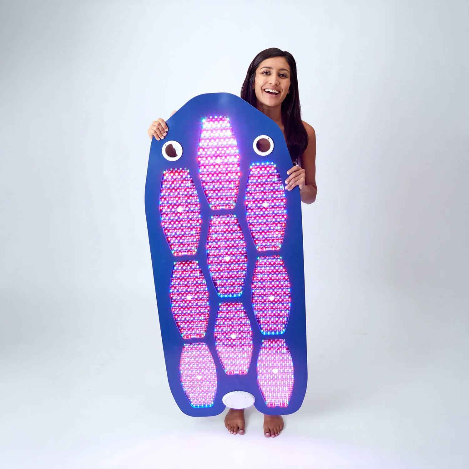 Woman holding Celluma DELUX II full-body LED Red light therapy with 4 modes for rejuvenation, pain relief, and wellness.