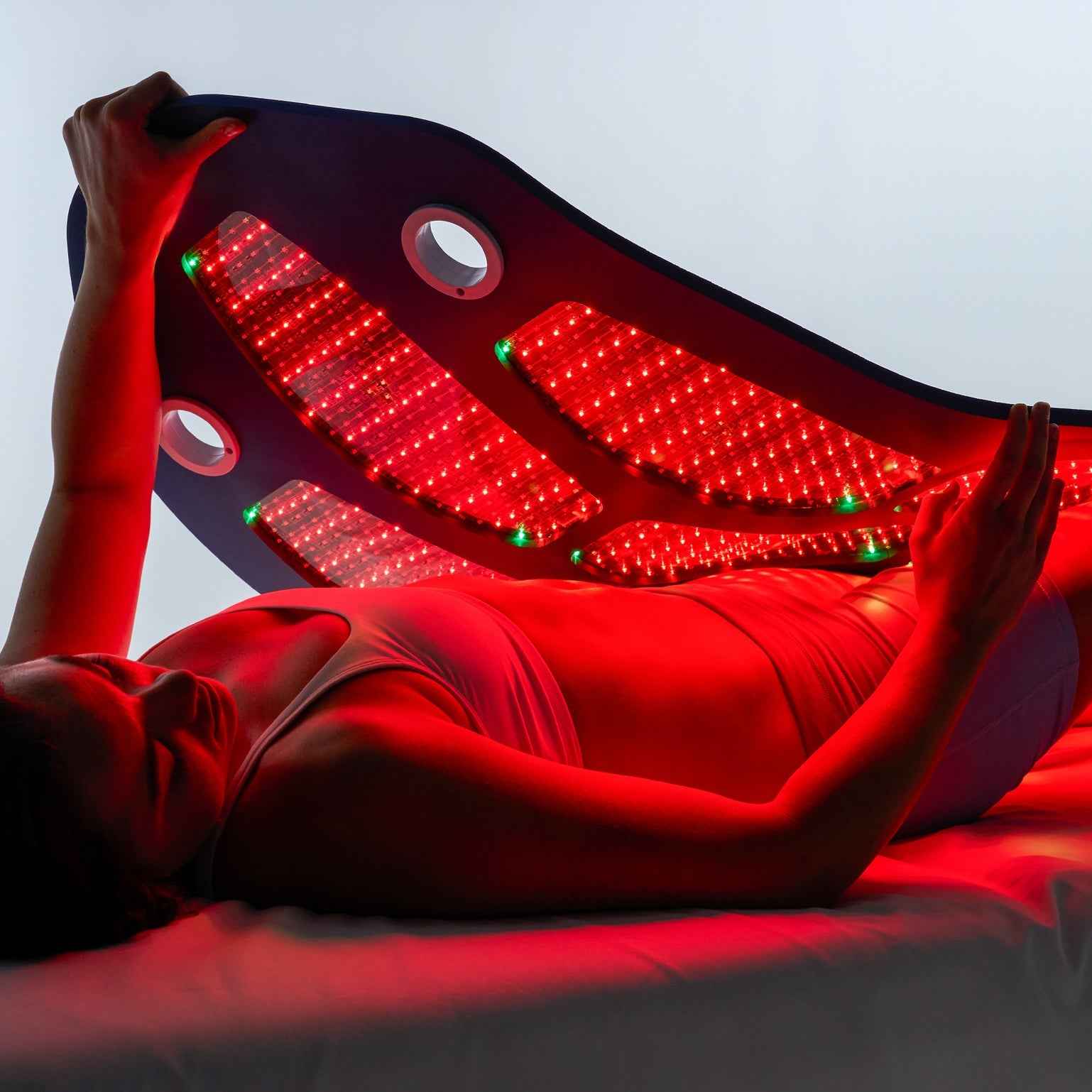 Person lying on Celluma DELUX II full-body LED red light therapy for rejuvenation, pain relief, and wellness.