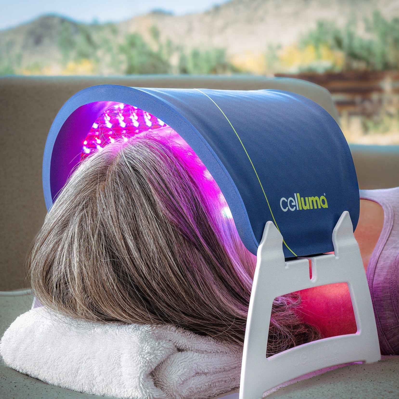 Woman using Celluma RESTORE LED Red Light Therapy for collagen boost and skin rejuvenation. 