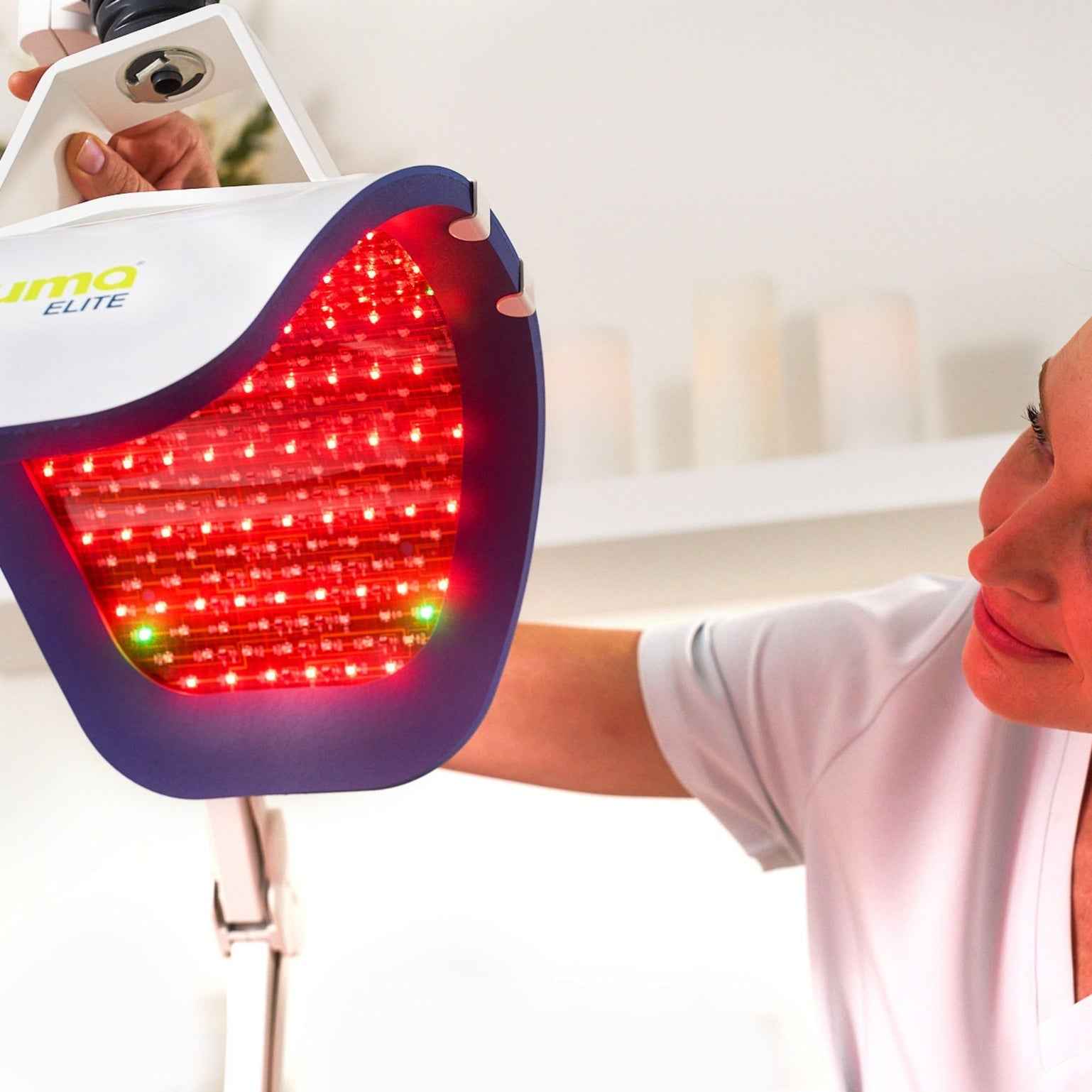 Aesthetician in a clinic standing next to the Celluma ELITE medical-grade LED Red light therapy system.